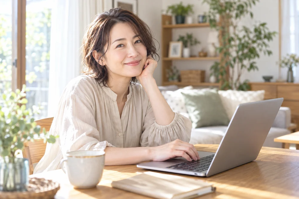 自宅でノートパソコンを使って学ぶ女性のイメージ